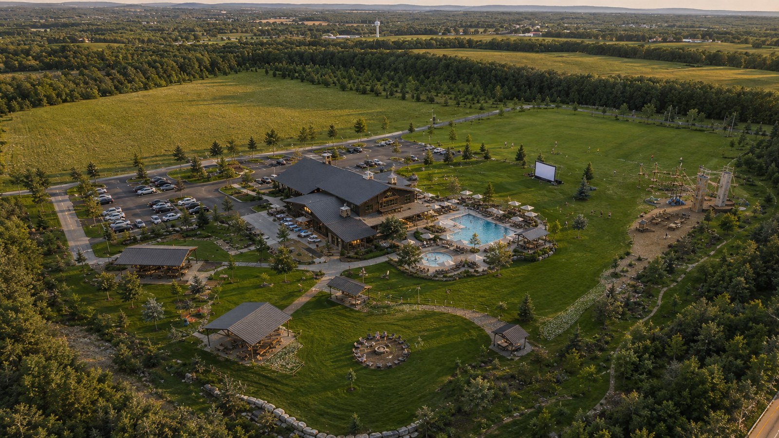 An aerial concept view of Camp Huntsville with lodge, lawns, play areas, and gathering spaces.